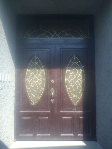 Puerta de dos hojas, en metal, imitación madera, con grabado